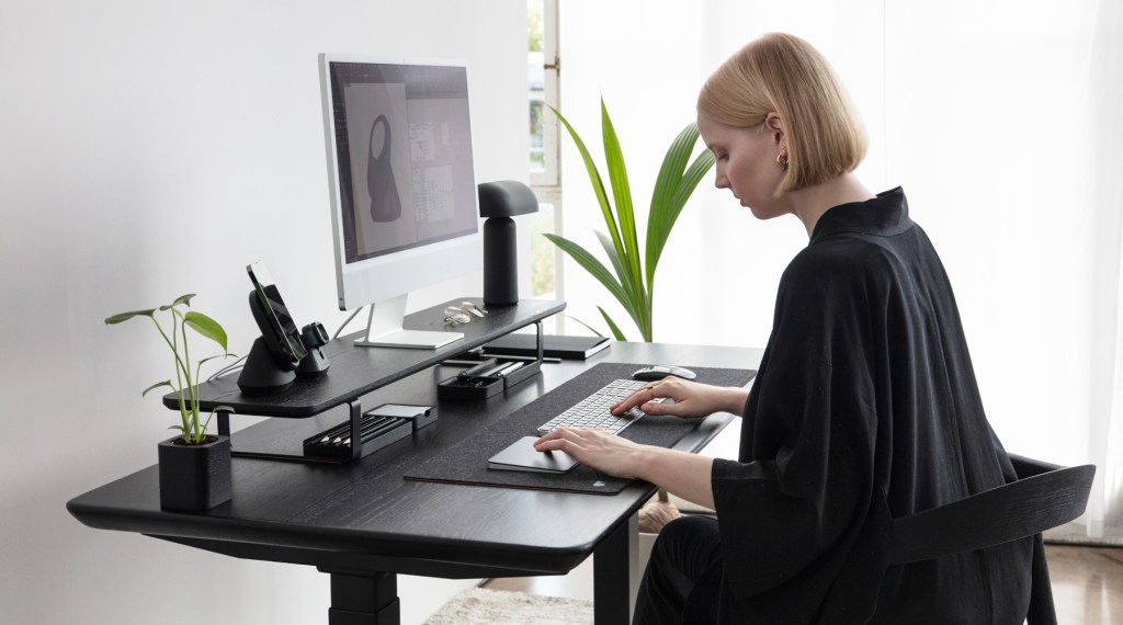 a person sitting at a table using a laptop computer