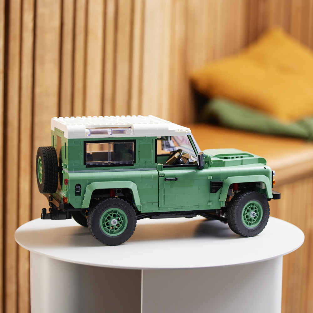 a green truck parked in front of a car