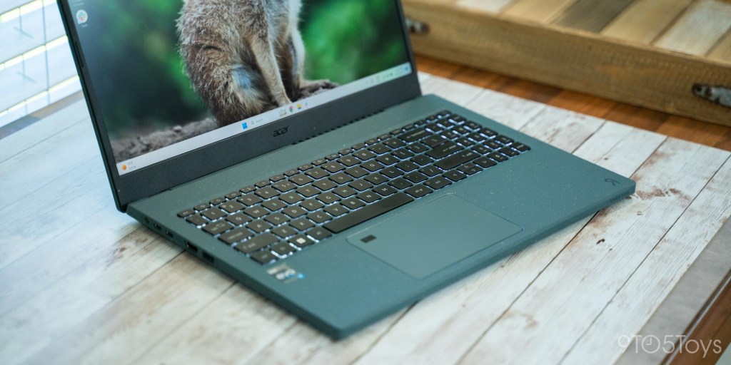 an open laptop computer sitting on top of a wooden table