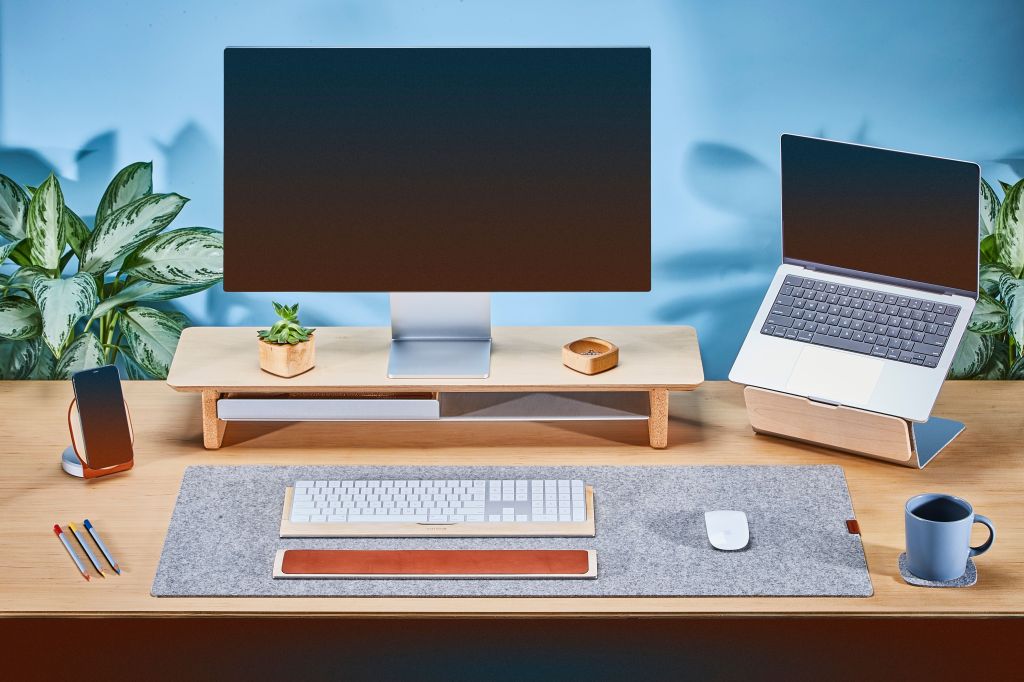 a desk with a laptop computer sitting on top of a table