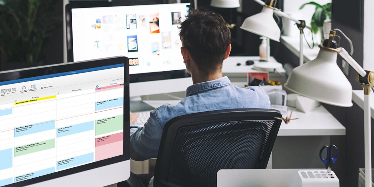 a man sitting at a desk in front of a computer screen