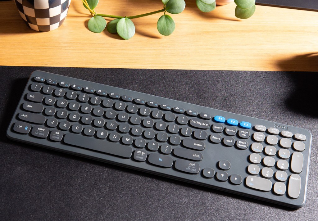 a desk with a computer keyboard sitting on top of a wooden table