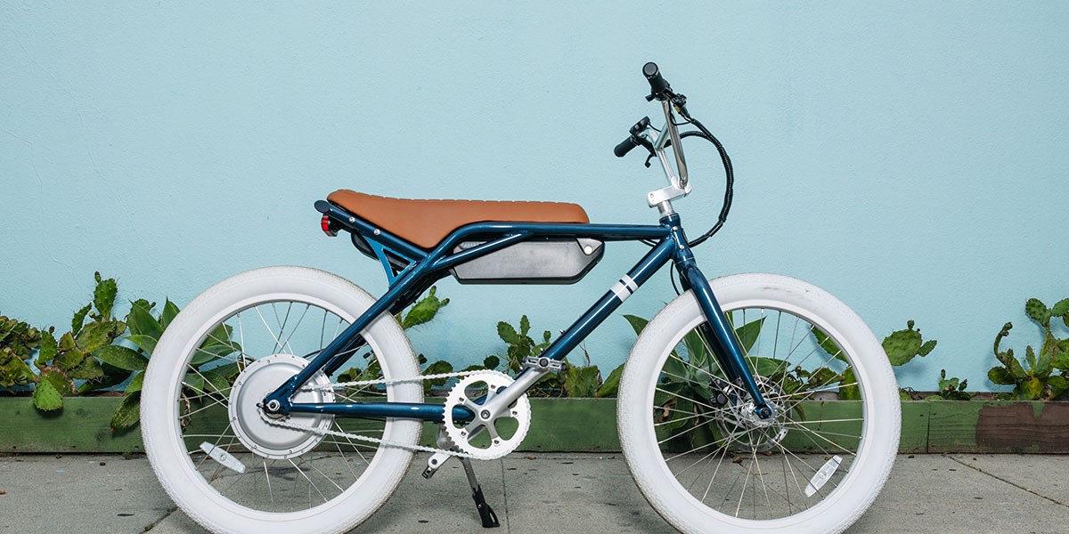 a bicycle parked in front of a brick wall