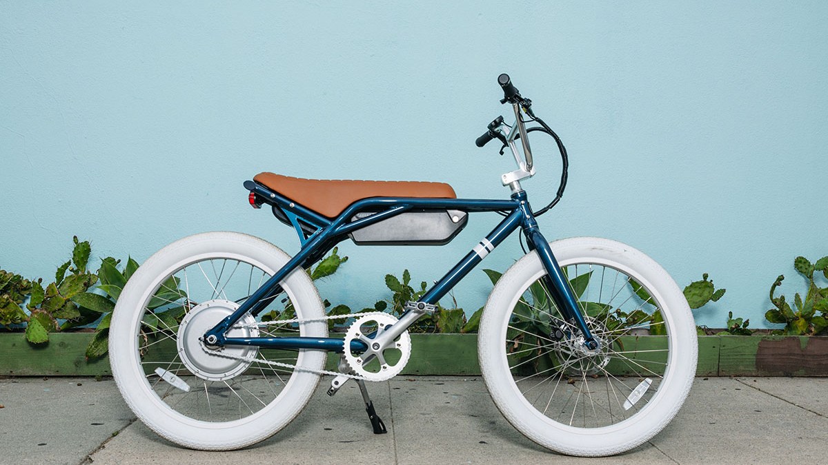 a bicycle parked in front of a brick wall