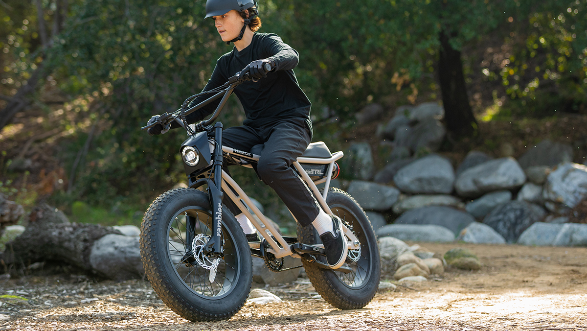 a man riding a motorcycle down a dirt road