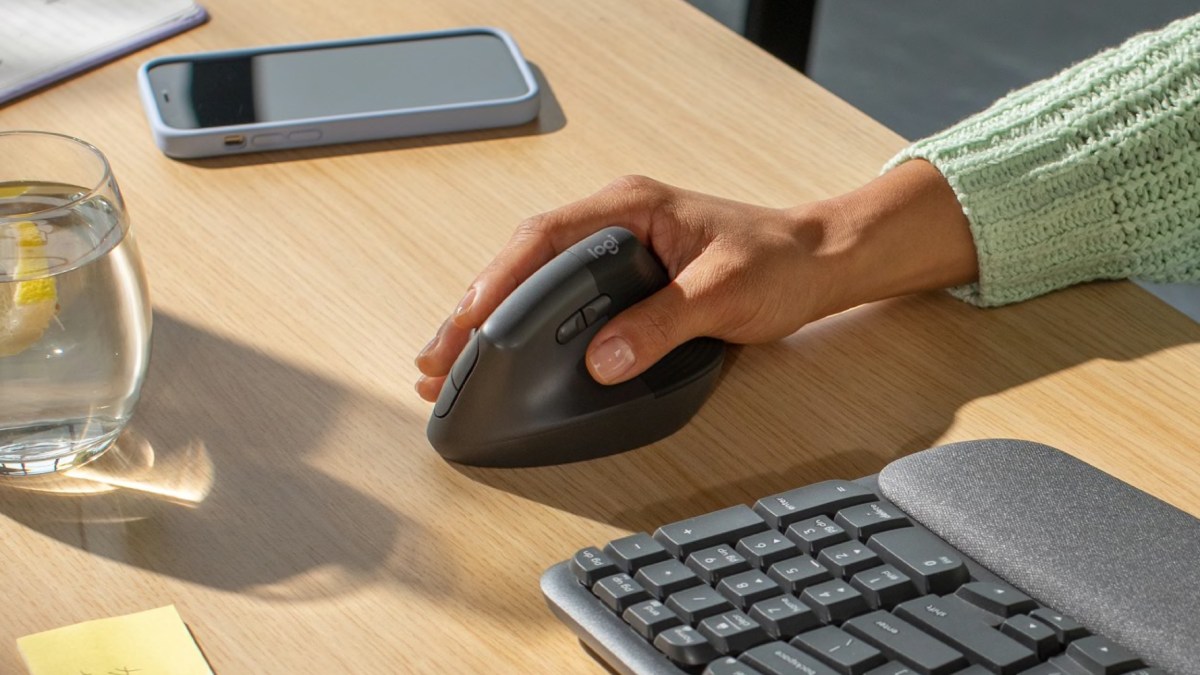 a person sitting at a desk in front of a keyboard