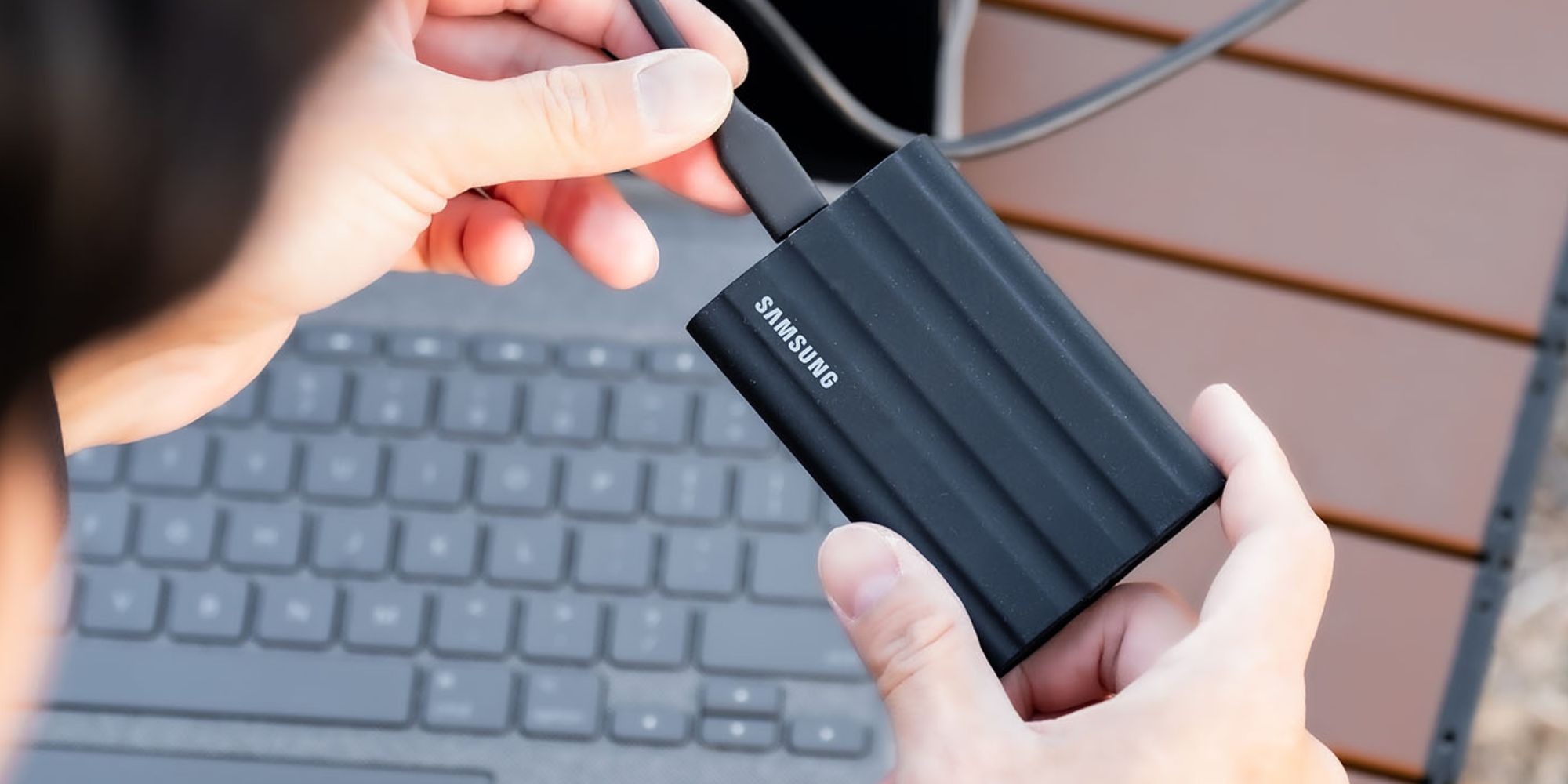 Image showing a person using Samsung T7 Shield portable SSD.