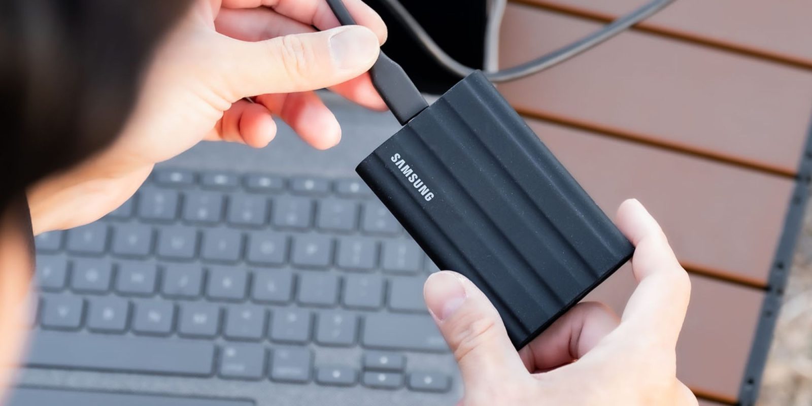 Image showing a person using Samsung T7 Shield portable SSD.