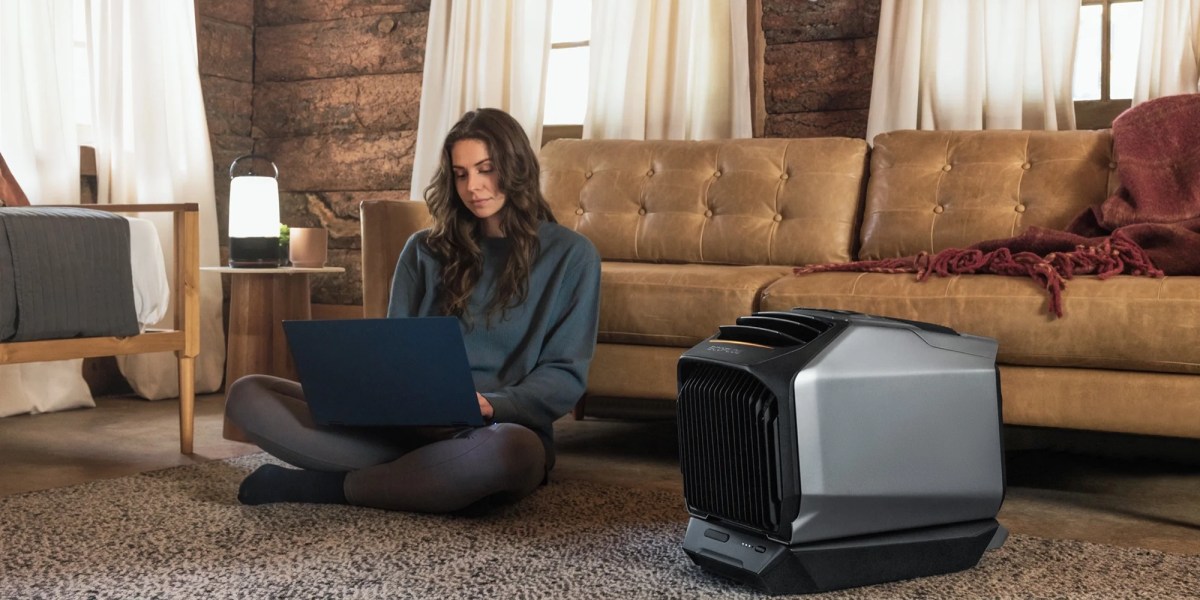 a person sitting on the floor with a laptop and a television