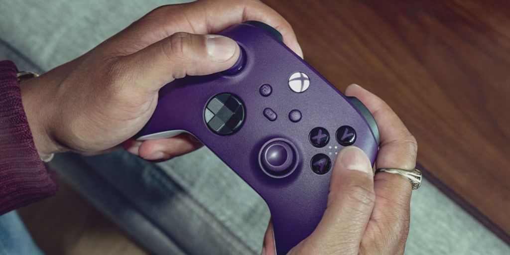 Image showing a person holding an Xbox controller in purple color.