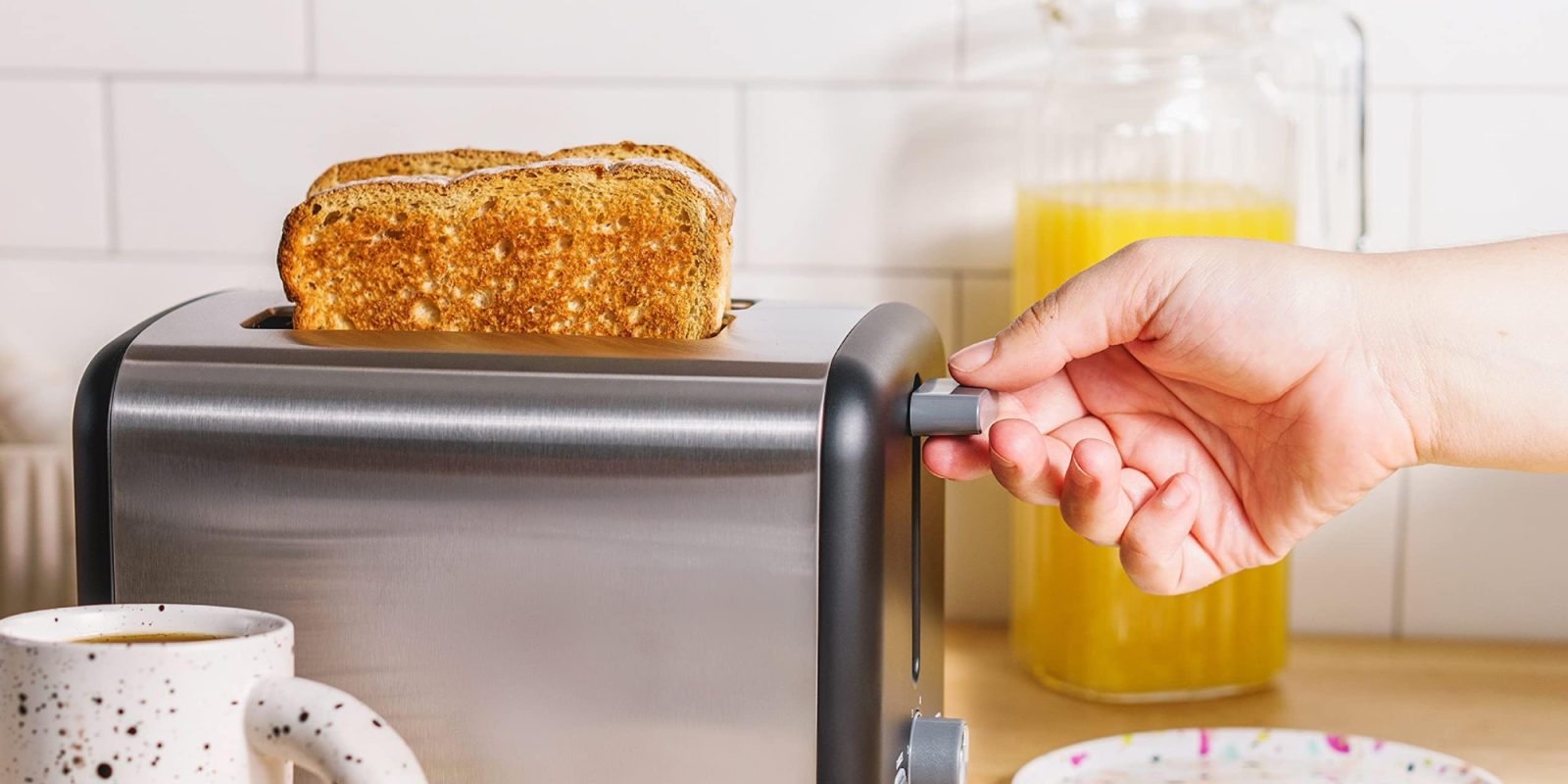 A hand pushing a toaster