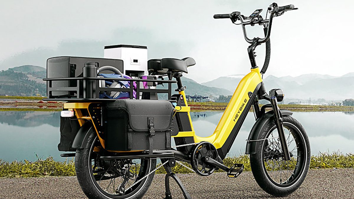 A yellow electric bike with a black basket on the back
