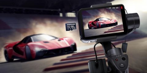 A video game controller with a screen and a red sports car