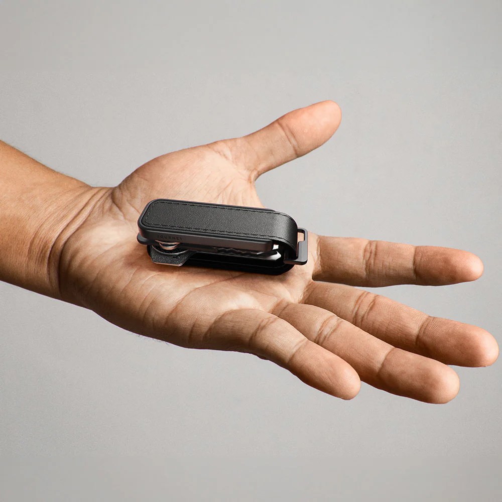 A hand holding a small black pocket knife