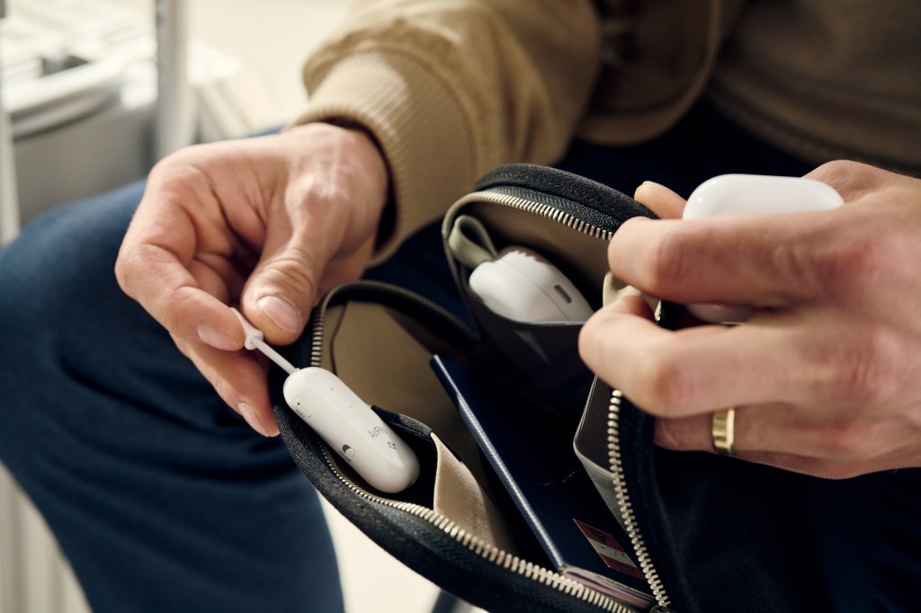 A person opening a bag with a white earbuds