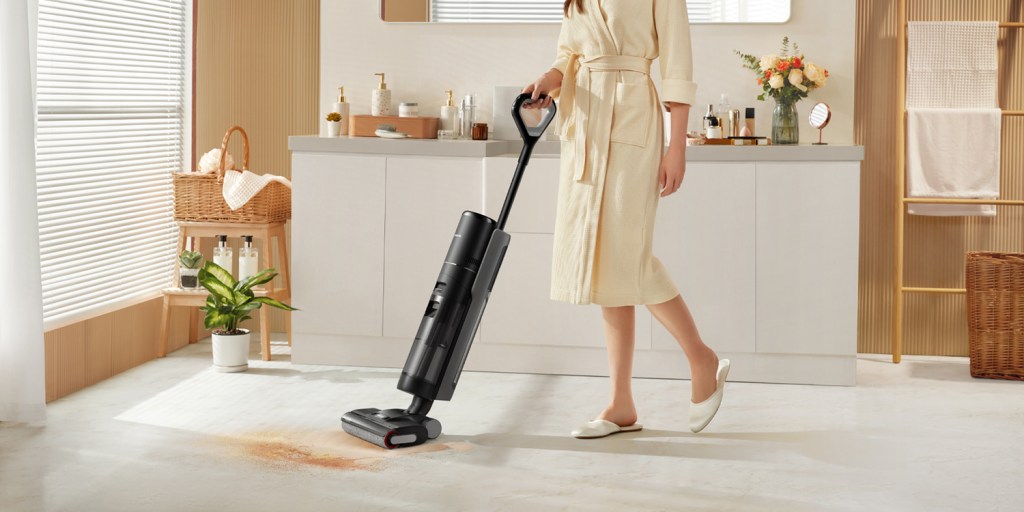 A woman in a robe with a vacuum cleaner