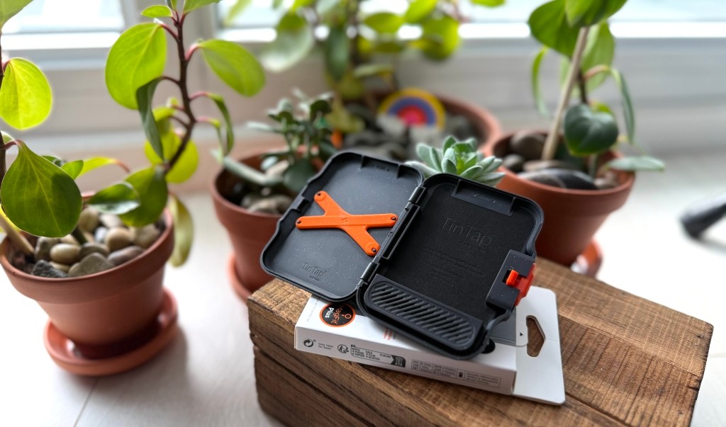 A small black box with orange straps on top of a box