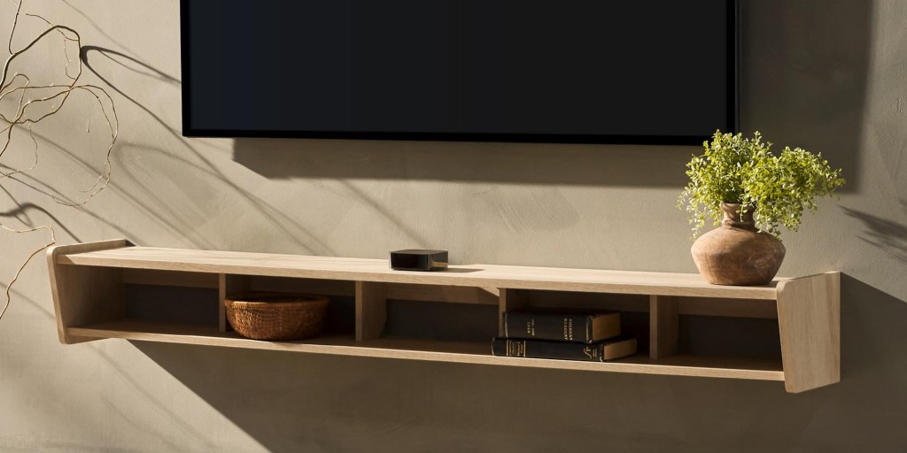 A shelf with books and a tv on the wall