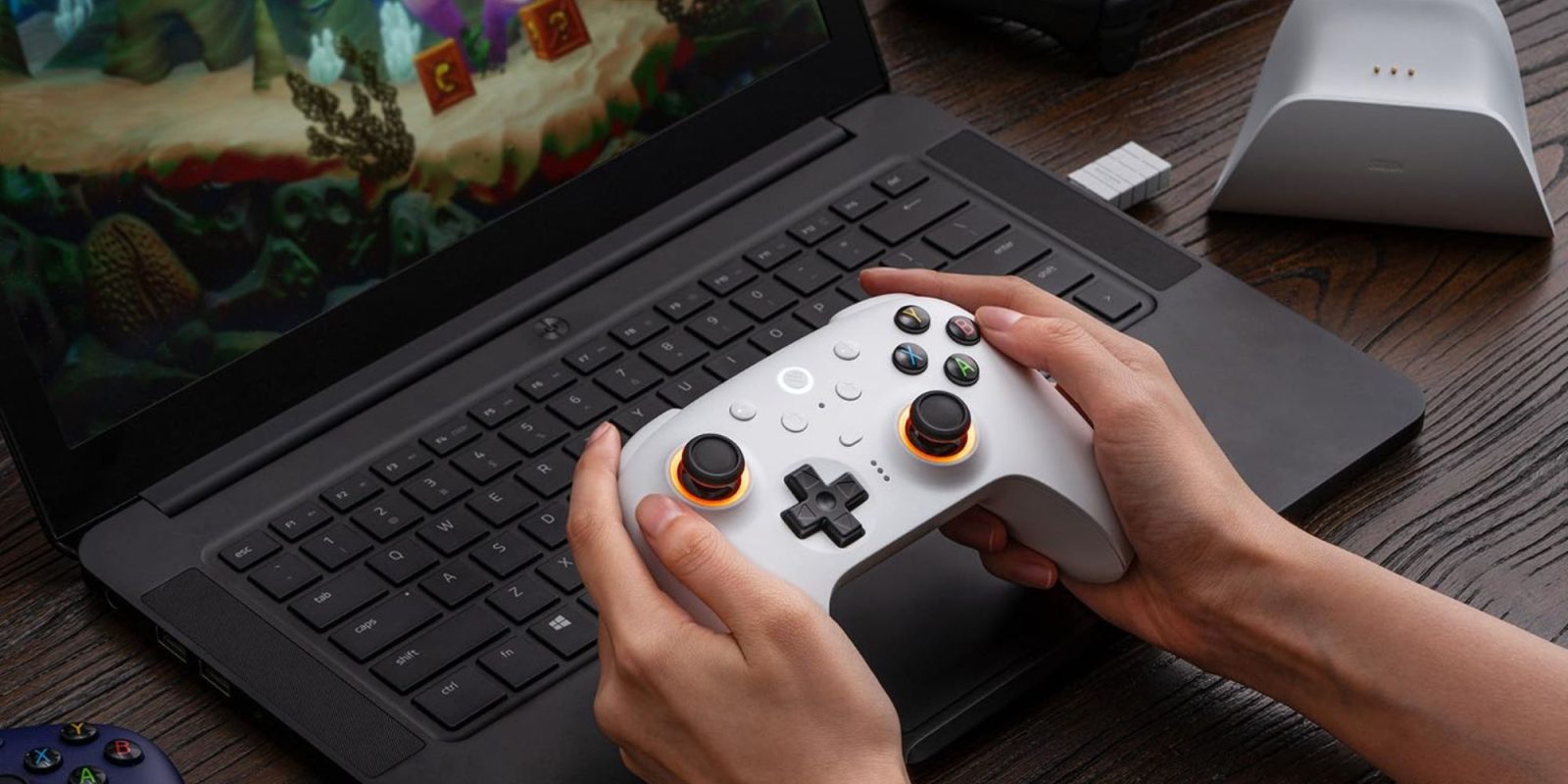 Image showing a person holding 8Bitdo's Ultimate wireless gamepad in white.