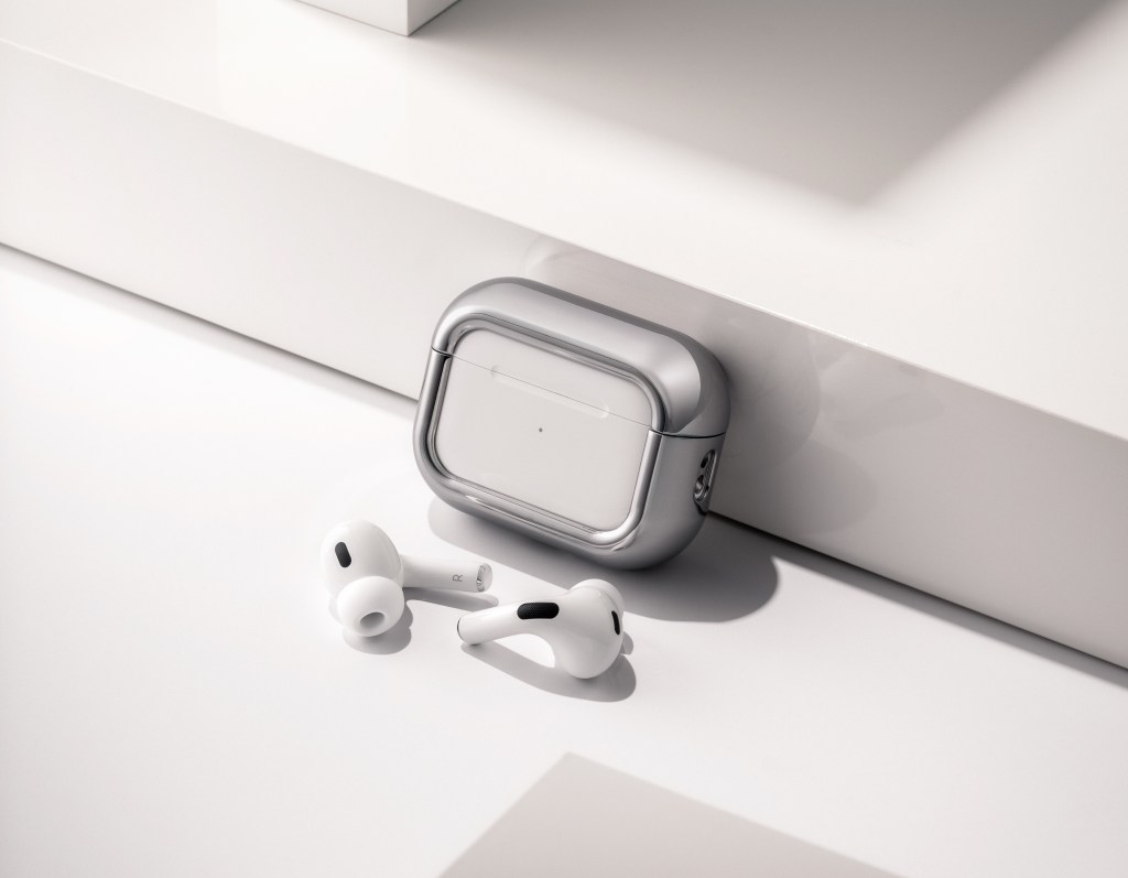 A pair of white earbuds on a white surface