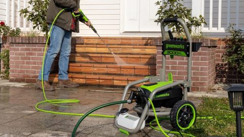 A person holding a hose and a power washer
