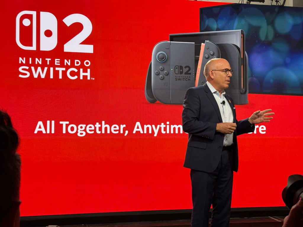 A man standing in front of a large screen