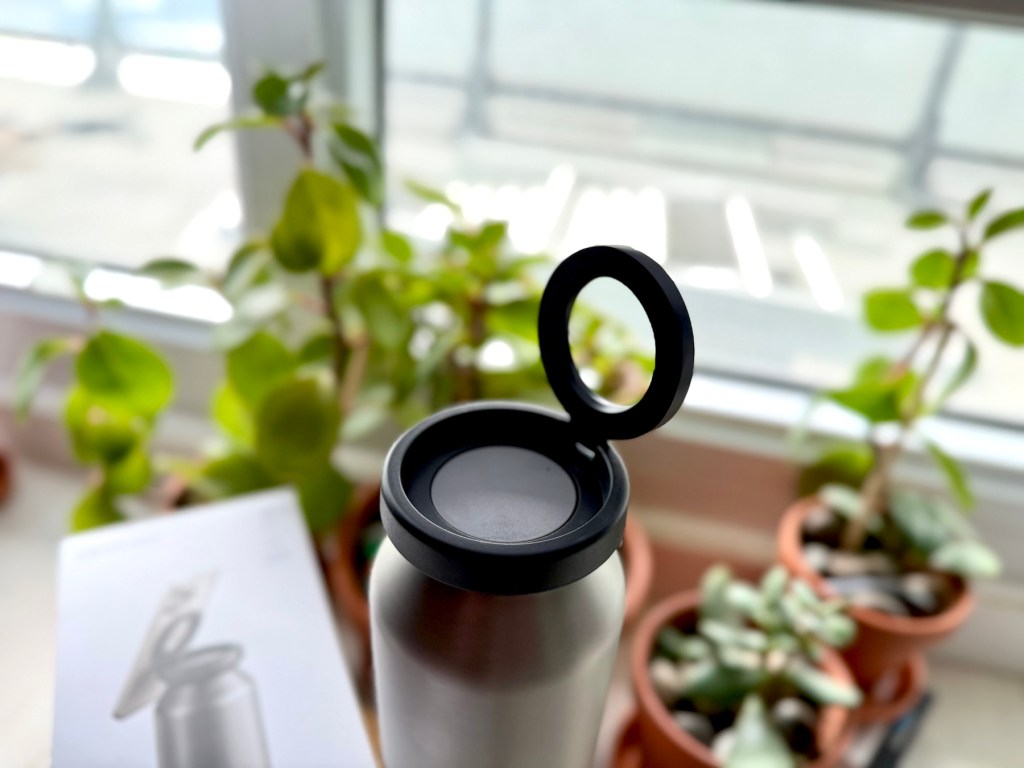 A silver bottle with a black lid