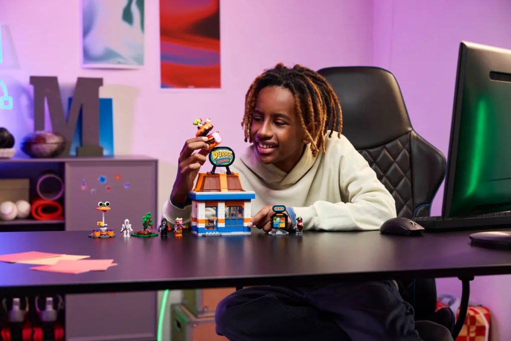 A boy sitting at a desk with toys