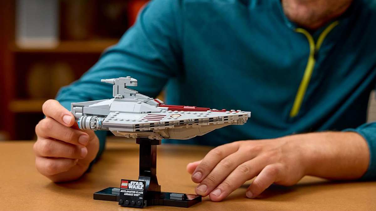 A person holding a toy model of a spaceship