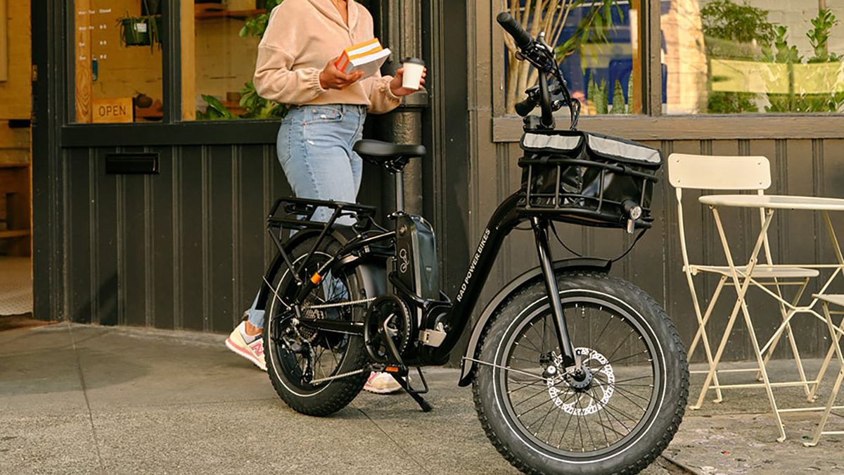 A woman standing on a bicycle