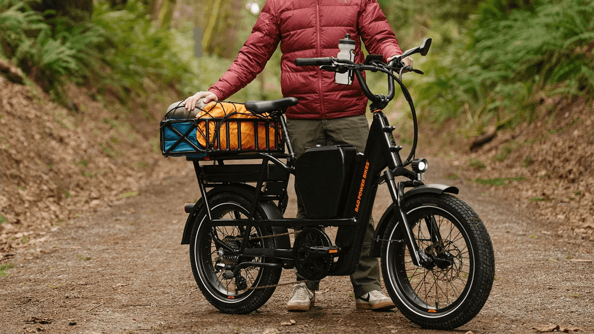 A person standing next to a black electric bike