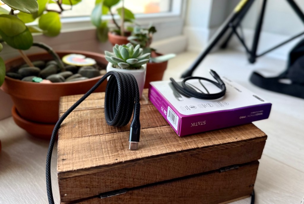 A box with a cord and a plant on it