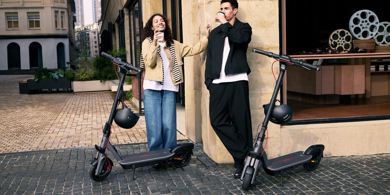 A man and woman standing next to a couple of scooters