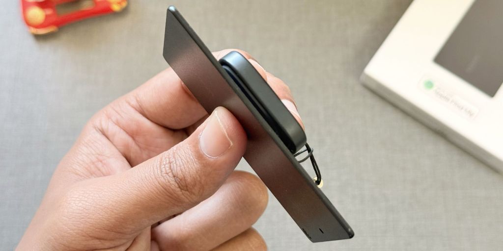 Image showing a person holding UGREEN's Find My compatible trackers.