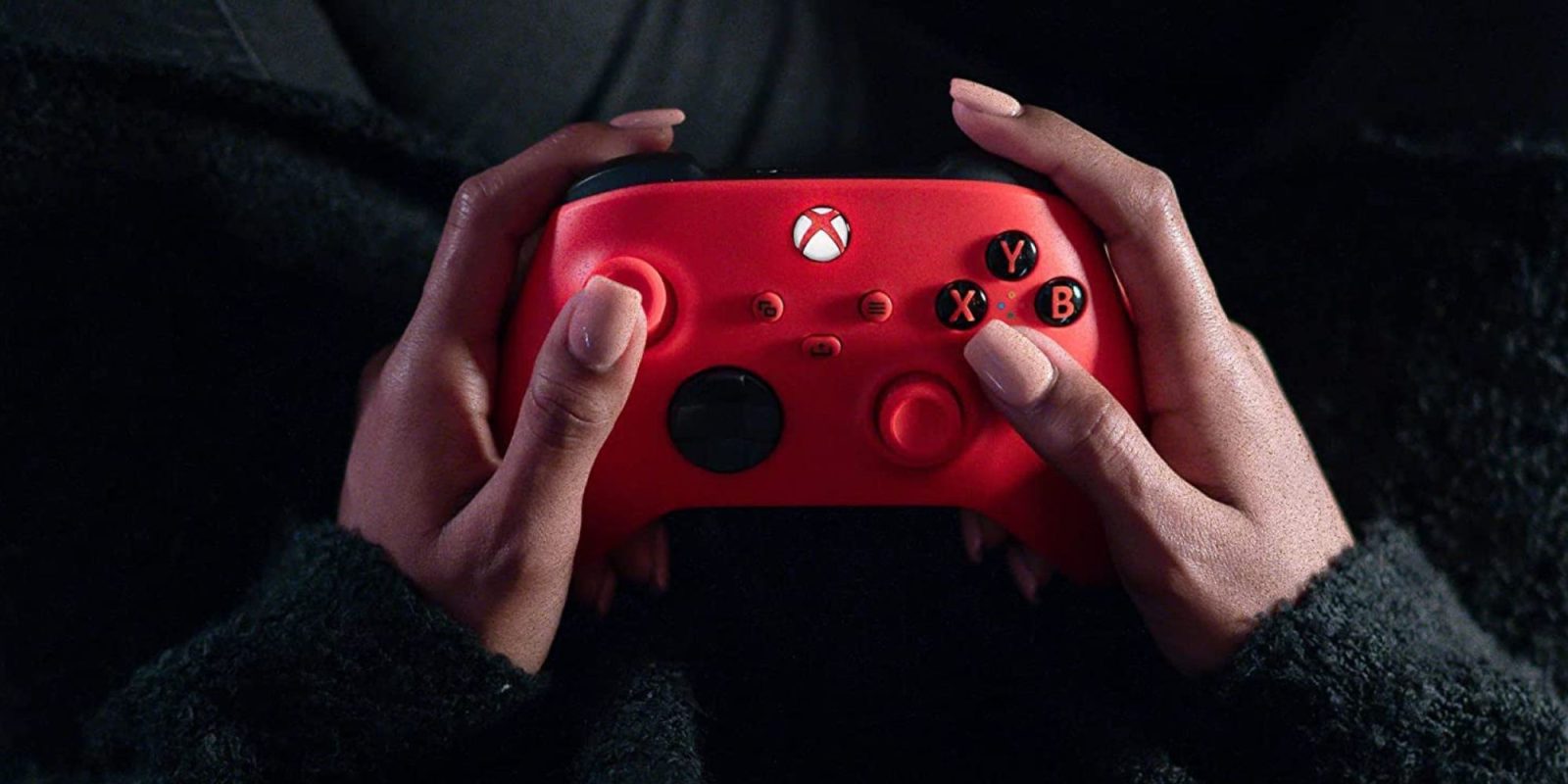 A person holding a red video game controller