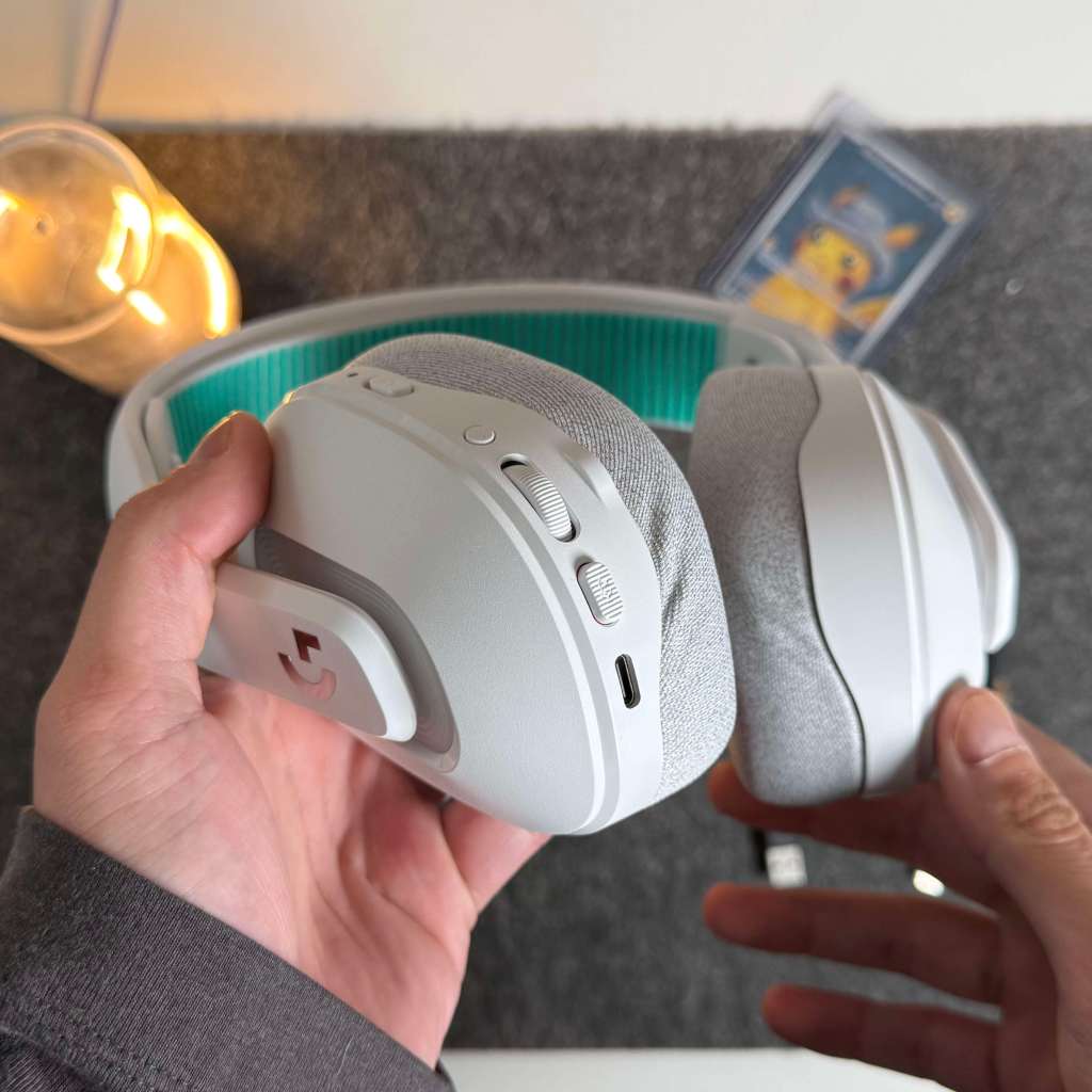 A pair of hands holding white headphones