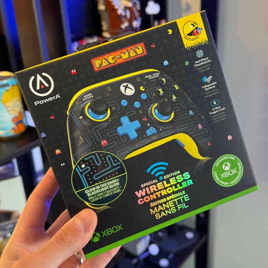 A hand holding a video game controller box