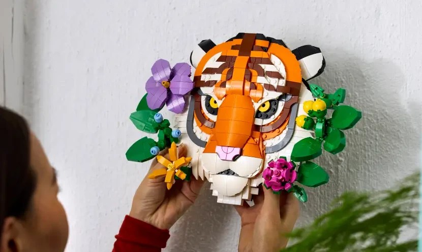 A person holding a lego tiger head