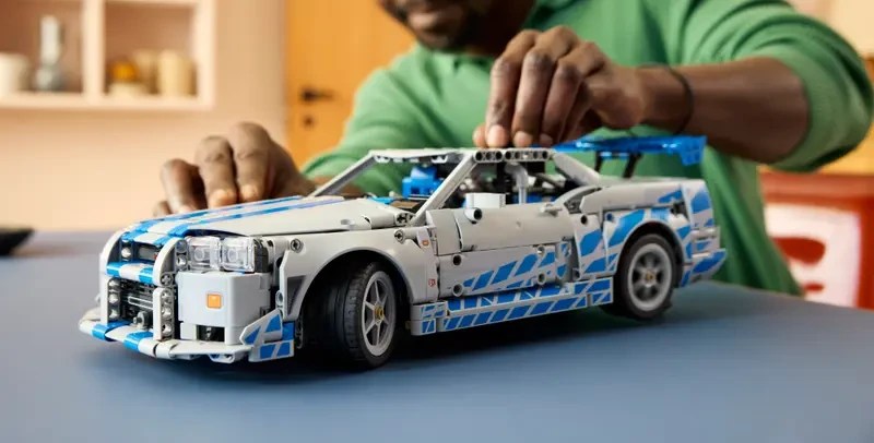 A man playing with a toy car