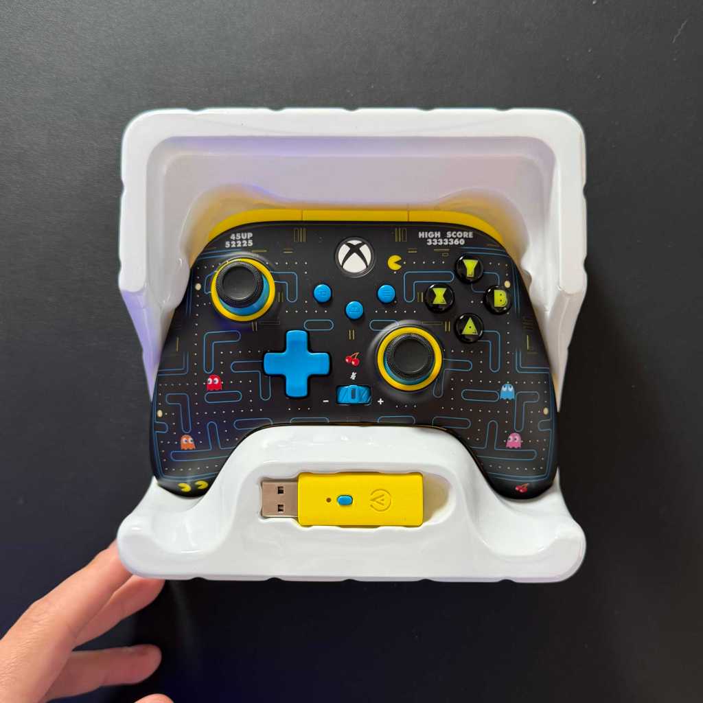 A hand holding a video game controller