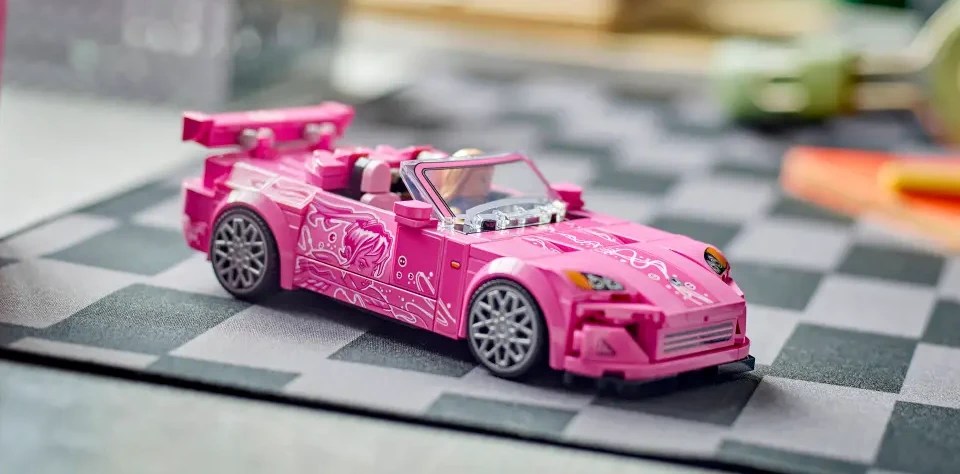 A pink toy car on a checkered surface