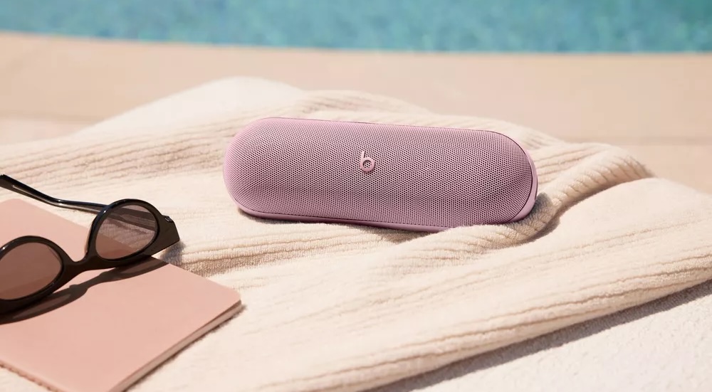 A pink speaker on a towel