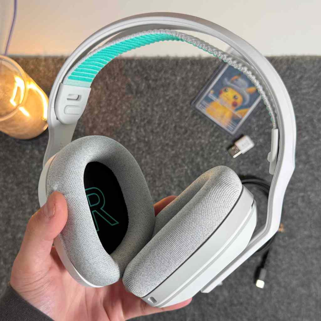 A hand holding a pair of headphones