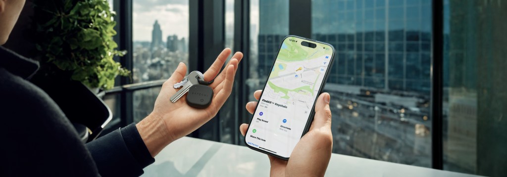 A person holding a cellphone and a key