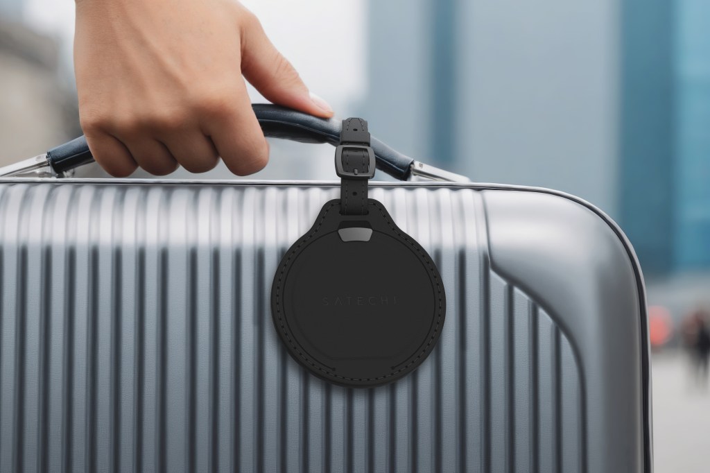 A hand holding a luggage tag