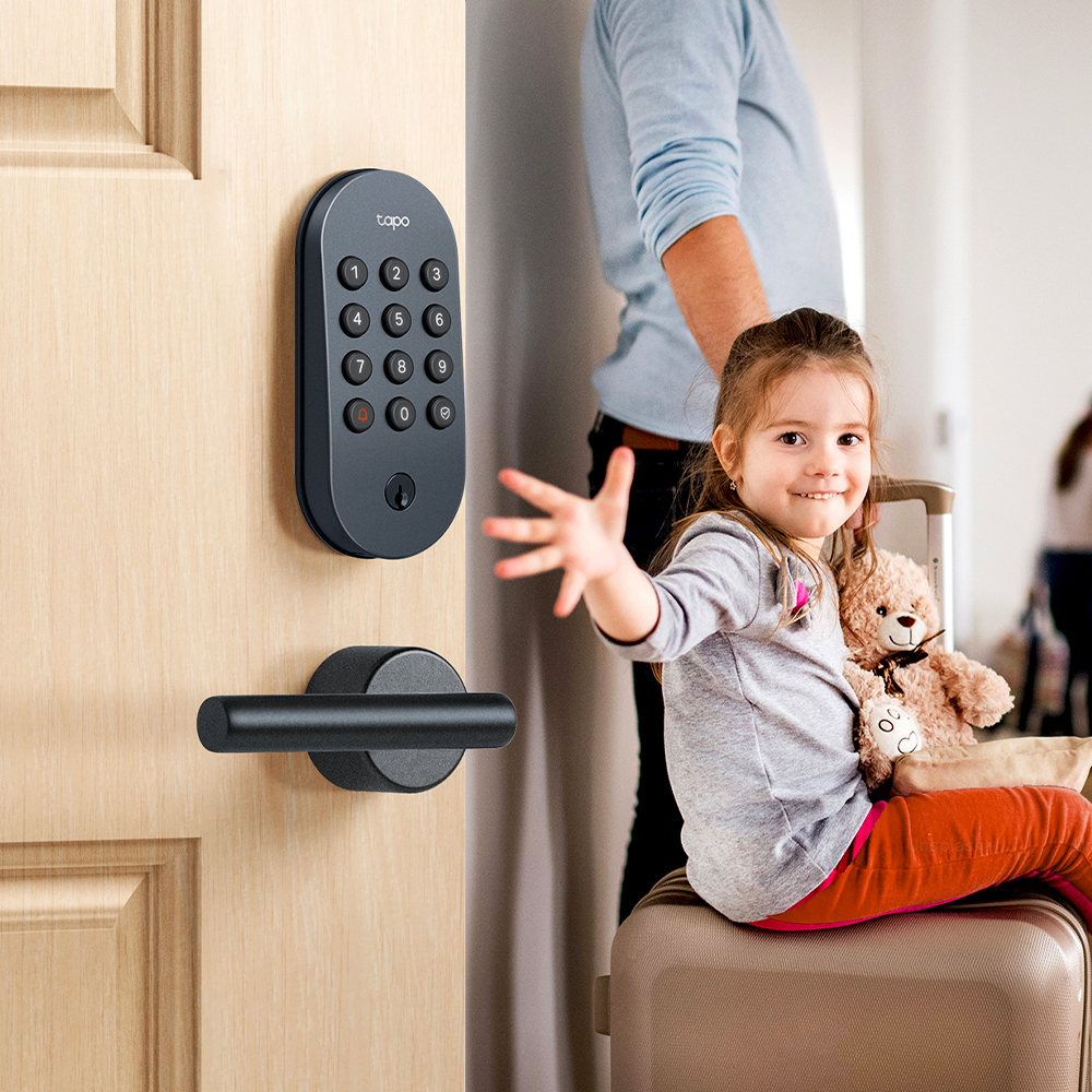A girl sitting on luggage with a teddy bear and a door lock