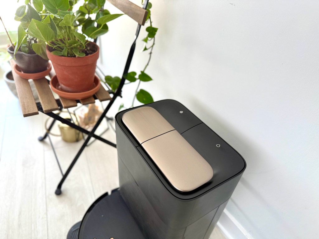 A black rectangular object with a gold button on top