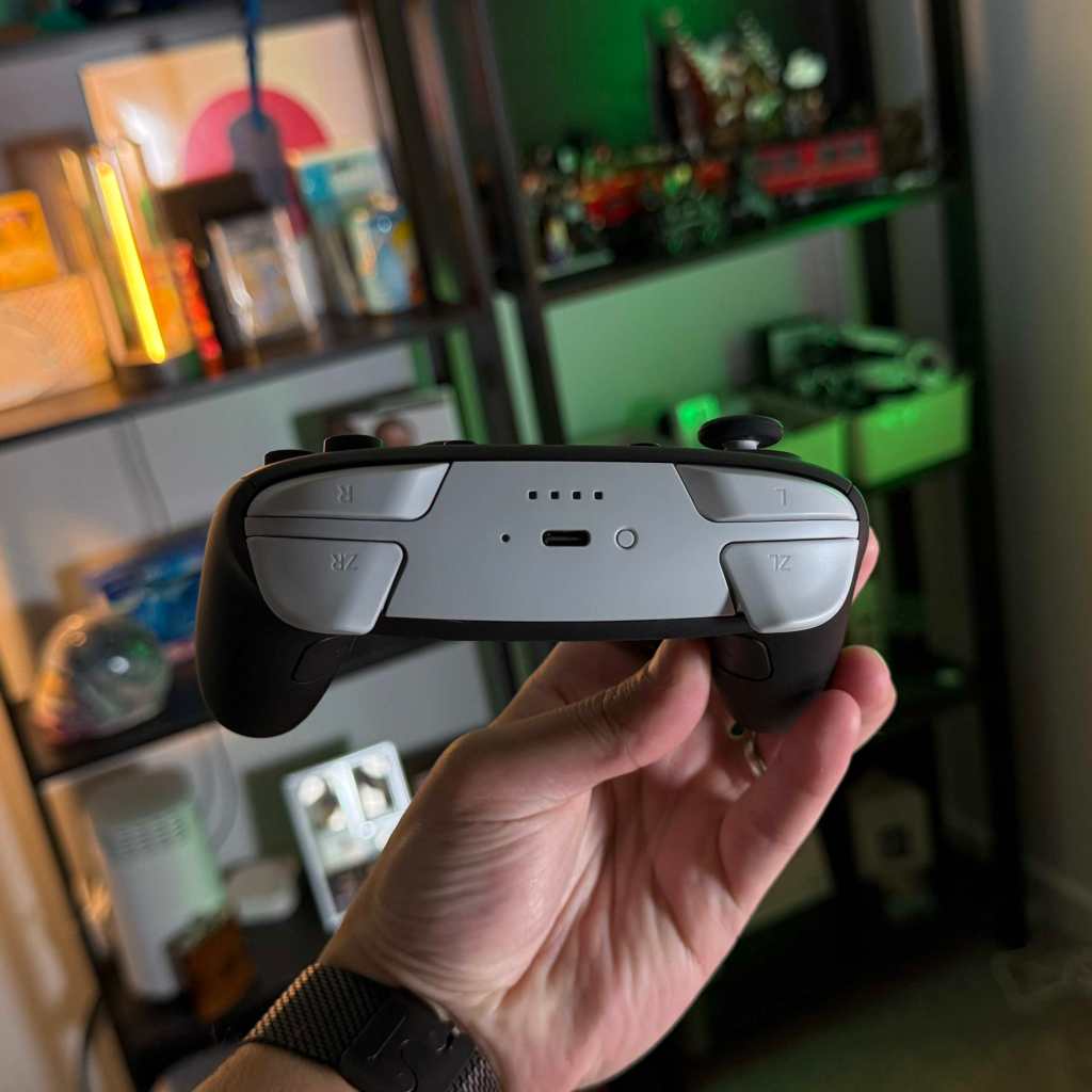 A hand holding a video game controller