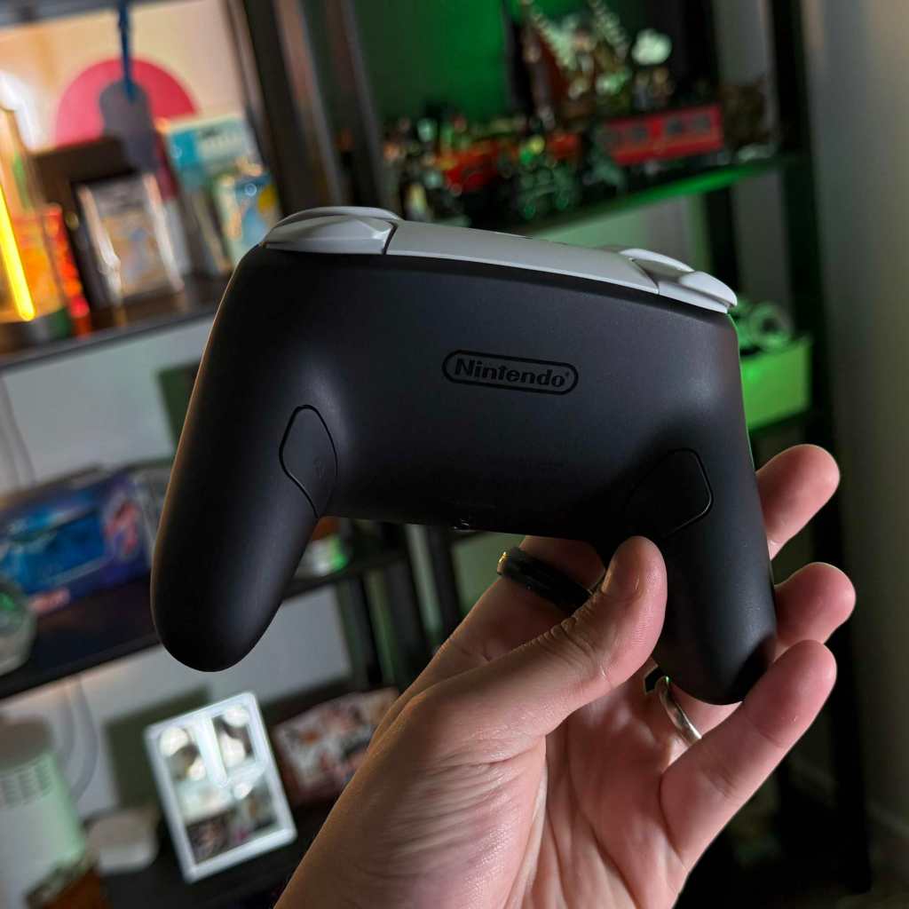 A hand holding a video game controller