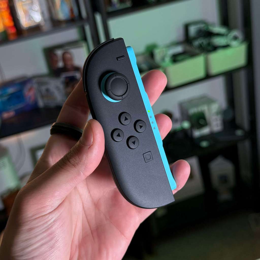 A hand holding a video game controller